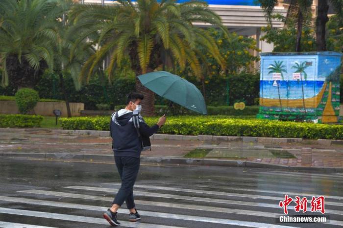 资料图：一行人冒雨出行。<a target='_blank' href='http://www.chinanews.com/'>中新社</a>记者 骆云飞 摄