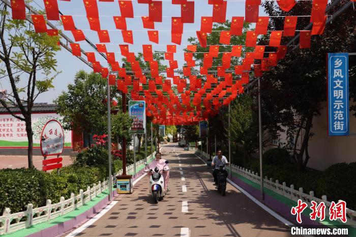 邢台市信都区羊范镇祁村道路干净整洁，道路两旁花木萦绕。　高晓博 摄