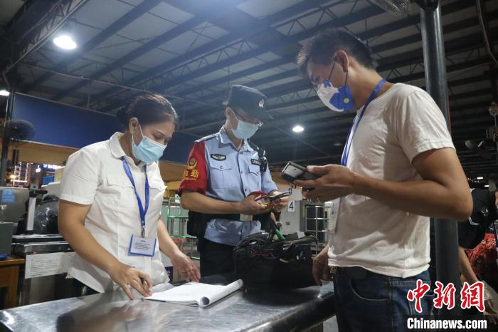 中秋节晚上，南宁站客运民警在安检口检查旅客携带的物品。　 冉景嘉 　摄